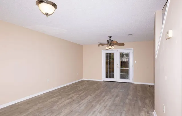 an empty room with wooden floor and windows