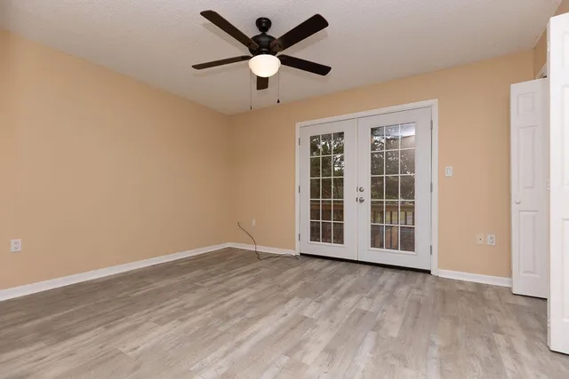an empty room with wooden floor and windows