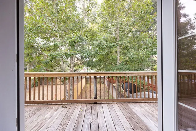 a balcony with wooden floor and yard
