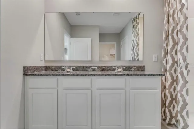 a bathroom with a granite countertop sink and vanity