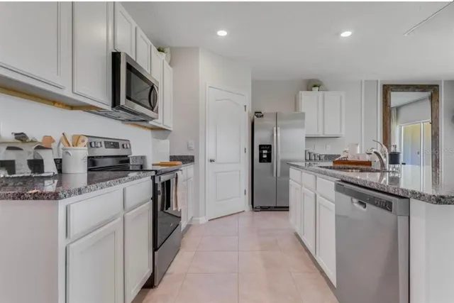 a kitchen with stainless steel appliances granite countertop a refrigerator sink and microwave