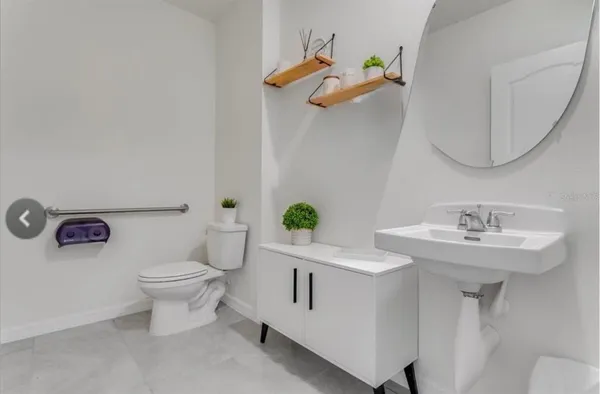 a bathroom with a toilet a sink and mirror