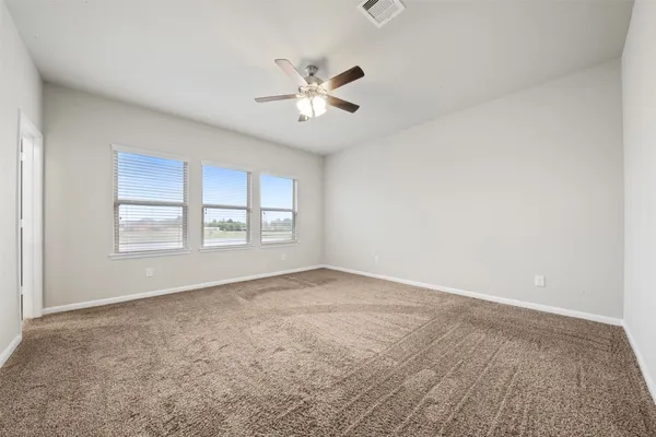 an empty room with a window and a fan