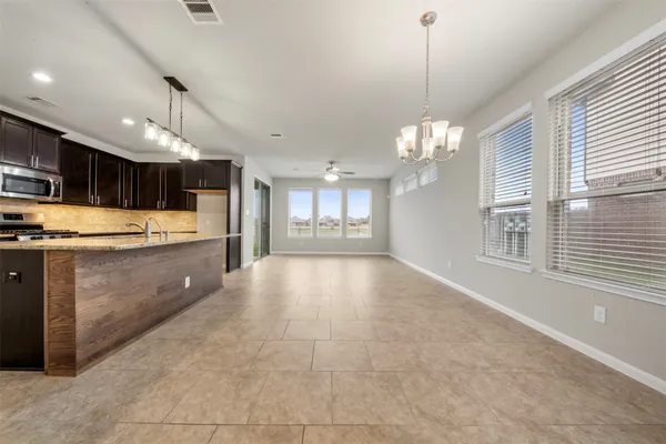 a large kitchen with kitchen island a chandelier appliances and a counter top space