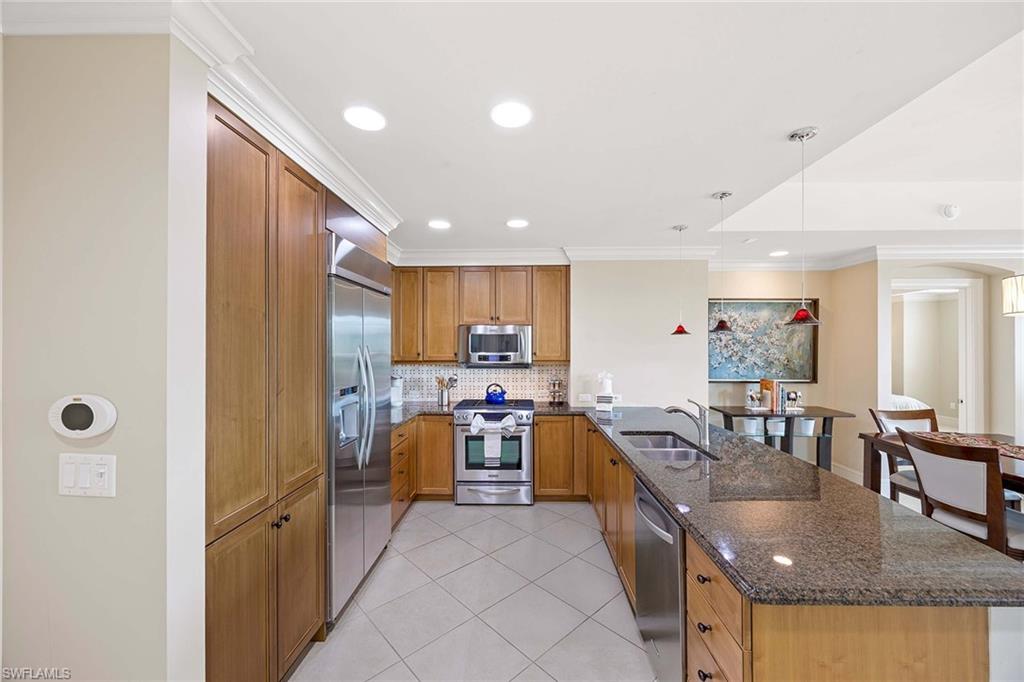 9115 Strada Place, Unit 5213 Naples, FL 34108 - Photo 12 of 32 a kitchen with stainless steel appliances granite countertop sink refrigerator and cabinets