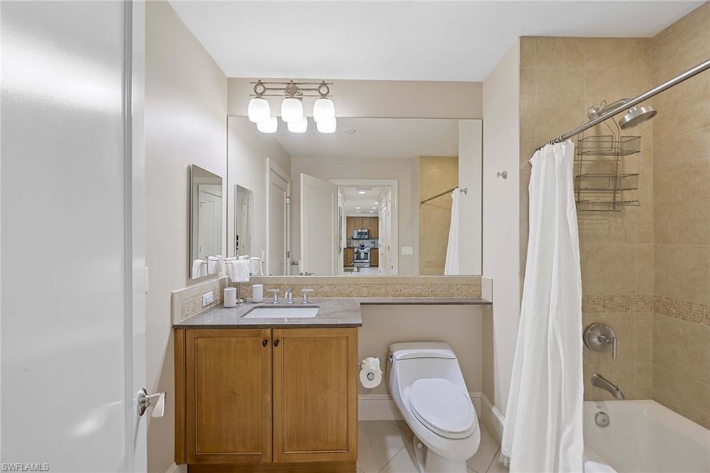9115 Strada Place, Unit 5213 Naples, FL 34108 - Photo 21 of 32 a bathroom with a granite countertop sink toilet and shower