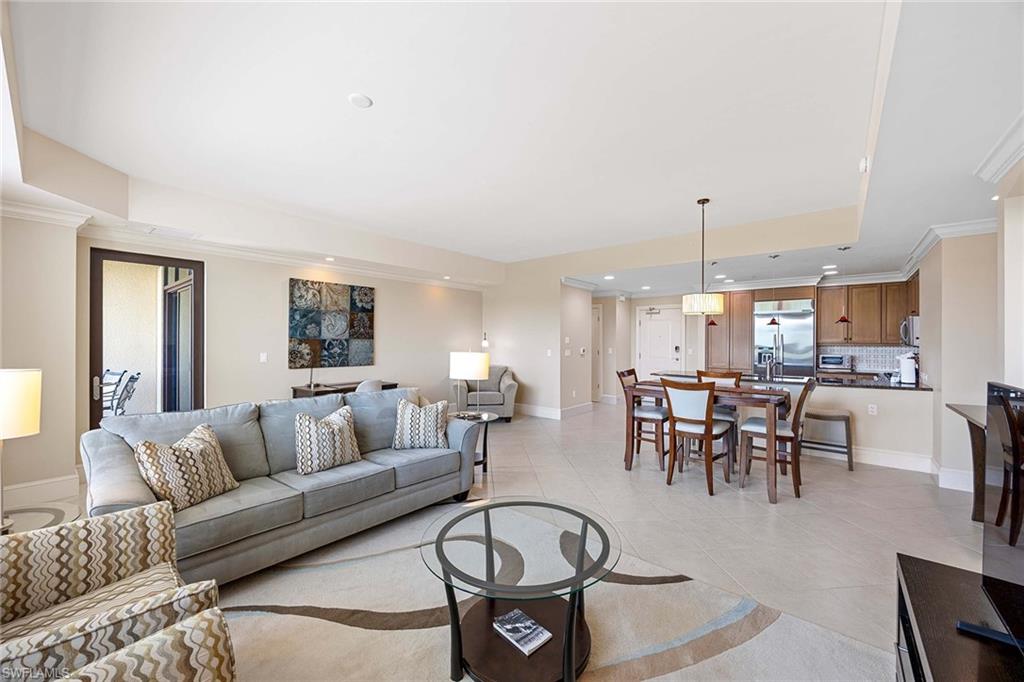 9115 Strada Place, Unit 5213 Naples, FL 34108 - Photo 9 of 32 a living room with furniture kitchen view and a chandelier