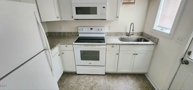 a view of a kitchen with sink washer and dryer