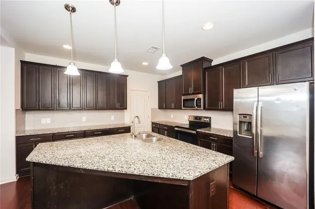 a kitchen with stainless steel appliances granite countertop granite counter tops refrigerator and cabinets