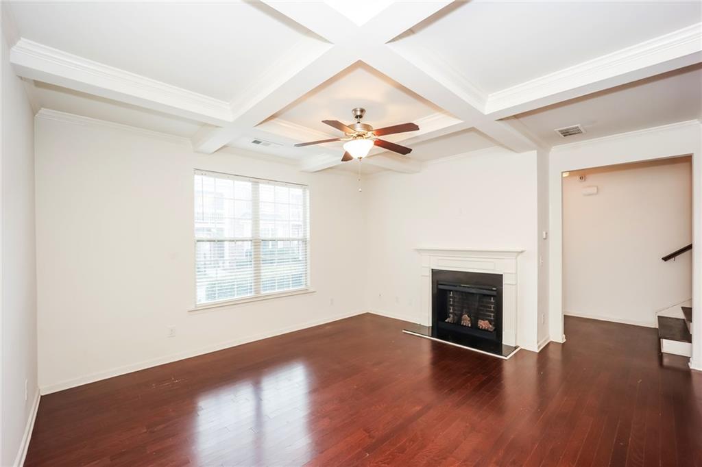7638 Bucknell Terrace Fairburn, GA 30213 - Photo 6 of 17 an empty room with wooden floor fireplace and windows