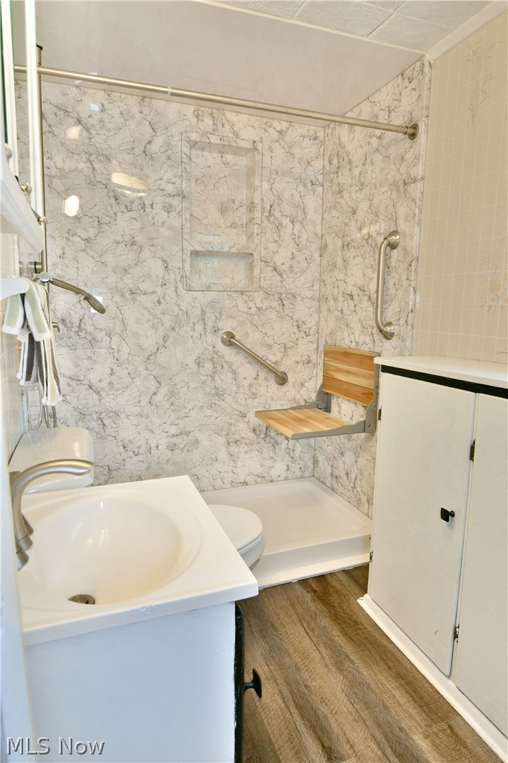 878 Ridge Road Vienna, OH 44473 - Photo 32 of 50 Full bathroom featuring vanity, a marble finish shower, tile walls, and dark wood-style floors