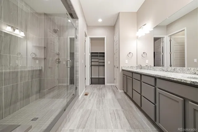 a spacious bathroom with a shower sink and mirror