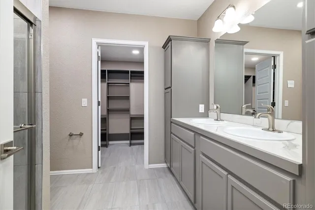 a bathroom with a double vanity sink a mirror and a shower