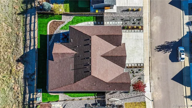 a aerial view of a house with a yard and potted plants