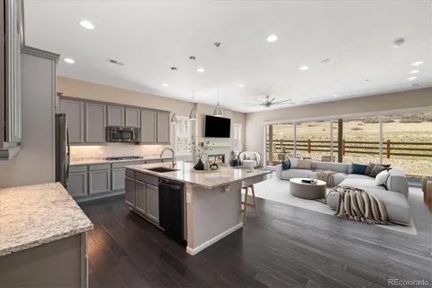 a open kitchen with stainless steel appliances granite countertop a lot of counter space and wooden floors