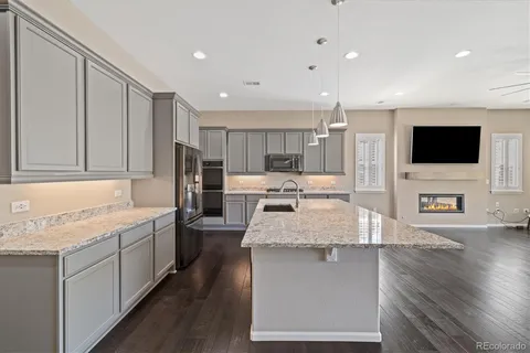 a large kitchen with stainless steel appliances granite countertop a large counter top a stove and a sink