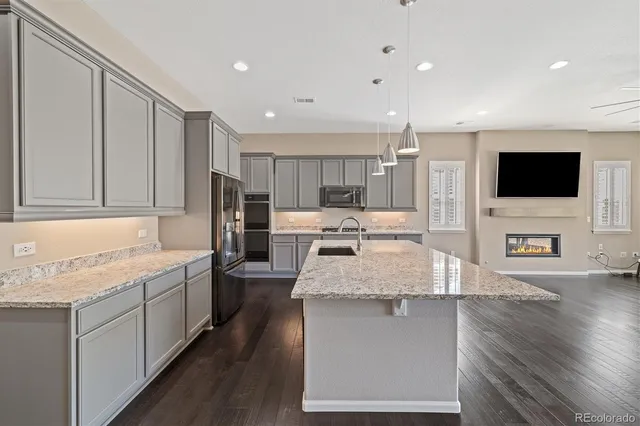 a large kitchen with stainless steel appliances granite countertop a large counter top a stove and a sink