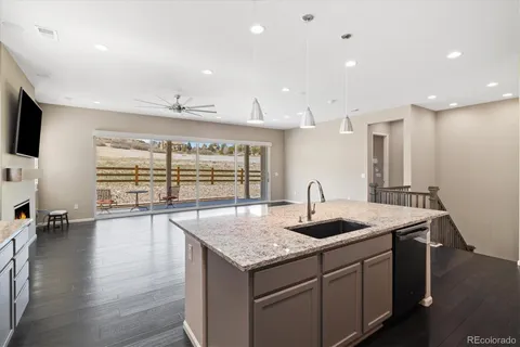 a kitchen with granite countertop kitchen island stainless steel appliances a sink and a large window