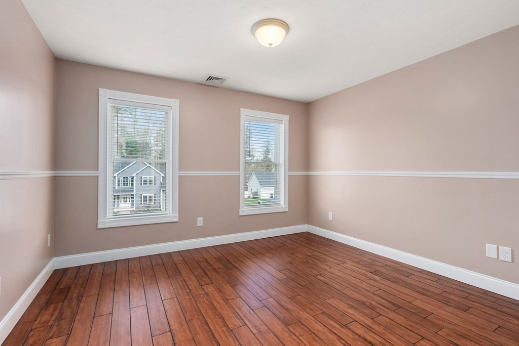 38 Draper Woods Road Sturbridge, MA 01518 - Photo 26 of 42 an empty room with wooden floor and windows