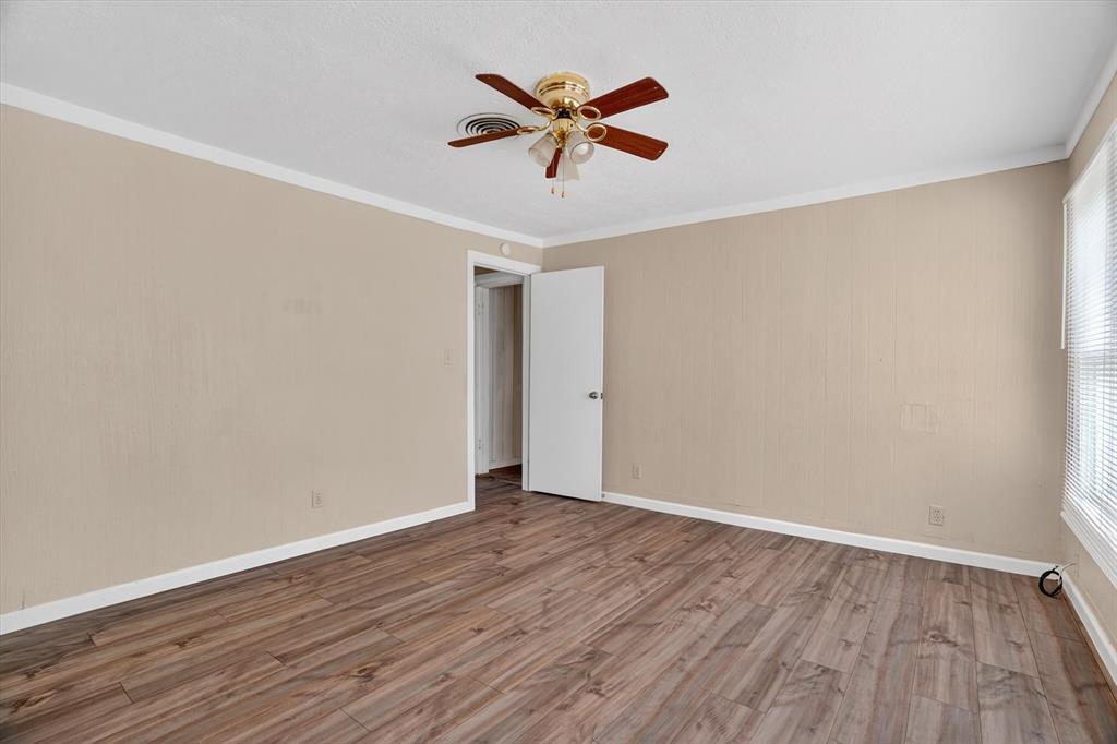 320 North 2nd Street Jacksboro, TX 76458 - Photo 14 of 16 an empty room with wooden floor and ceiling fan