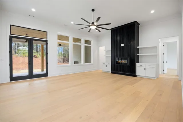 a view of an empty room with a ceiling fan and window