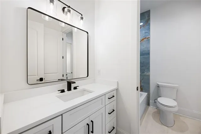 a bathroom with a sink a toilet and mirror