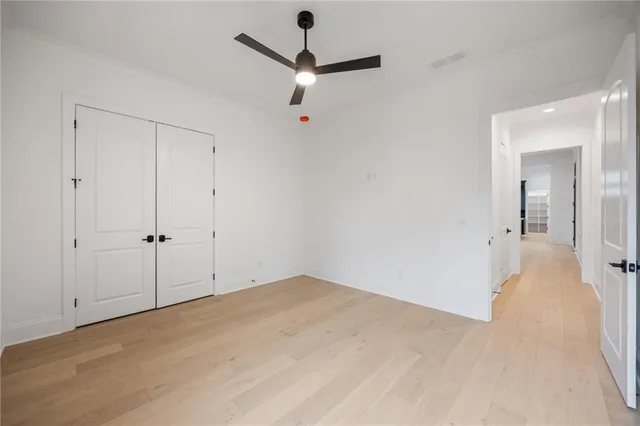 a view of a room with a ceiling fan and hardwood floor