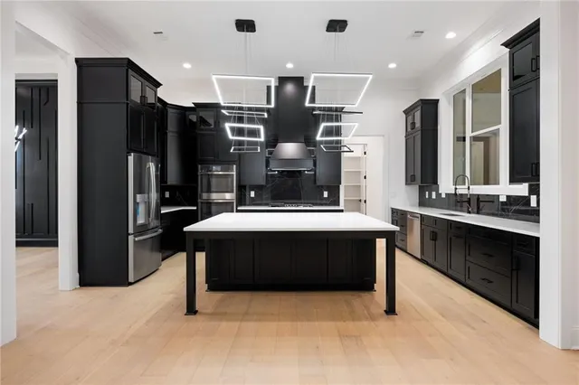 a large kitchen with a large counter top stainless steel appliances and cabinets