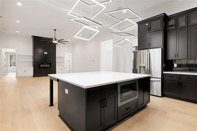 a kitchen with stainless steel appliances granite countertop a refrigerator a sink and a stove