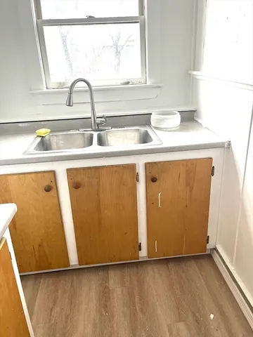 a view of empty room with window and wooden floor
