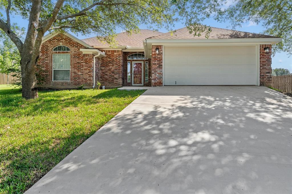10109 Barcelona Court Waco, TX 76708 - Photo 1 of 1 View of front of home with brick siding, a garage, driveway, and roof with shingles