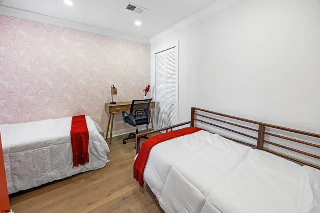 a bedroom with a bed and wooden floor