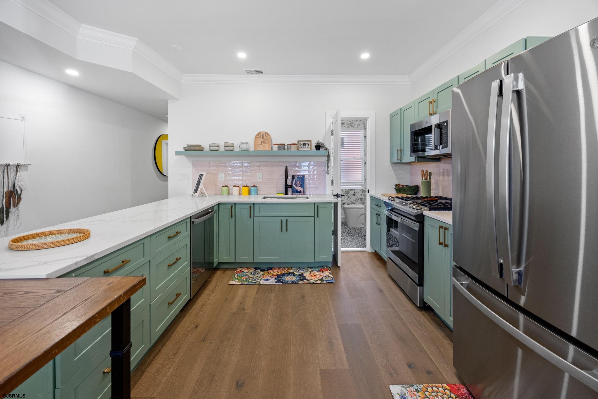 129 Seaside Avenue Atlantic City, NJ 08401 - Photo 5 of 43 a kitchen with kitchen island a counter top space a sink stainless steel appliances and cabinets