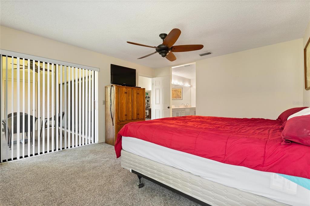 1801 East Lake Road South, Unit 4E Palm Harbor, FL 34685 - Photo 20 of 26 a bedroom with a bed and a chandelier