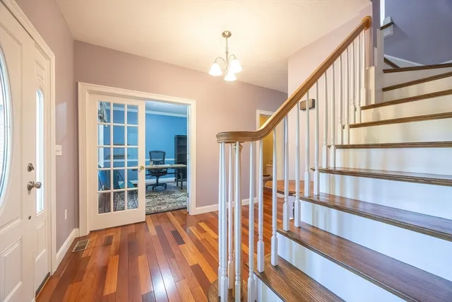 a view of a hallway with wooden floor and stairs