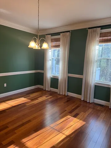 a view of empty room with window and wooden floor