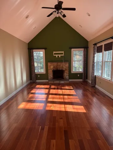 a living room with a fireplace windows and wooden floor