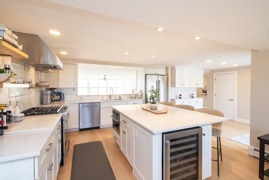 113 Glades Road Scituate, MA 02066 - Photo 16 of 41 a kitchen with a sink a stove a refrigerator and white cabinets