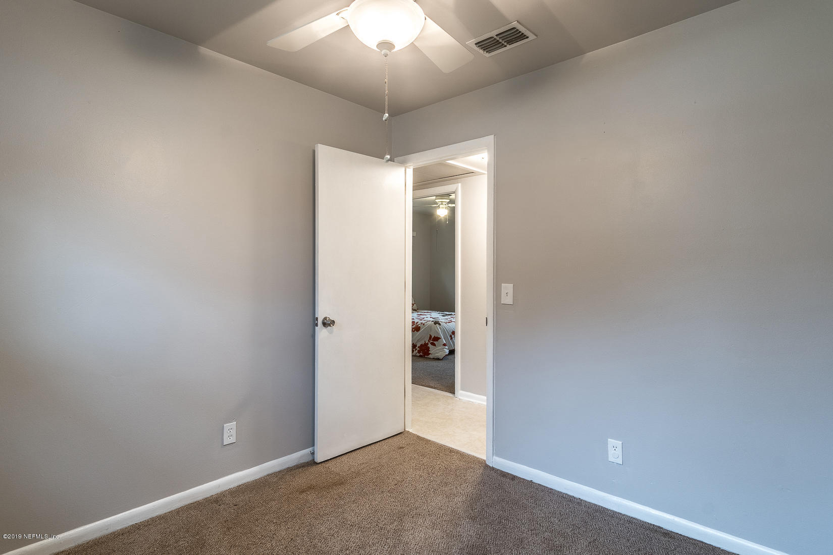7478 Strato Road Jacksonville, FL 32210 - Photo 19 of 24 an empty room with closet and a chandelier fan