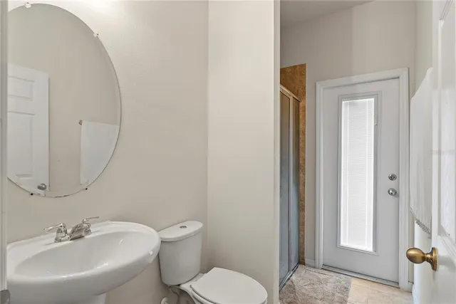 a bathroom with a toilet a sink and mirror