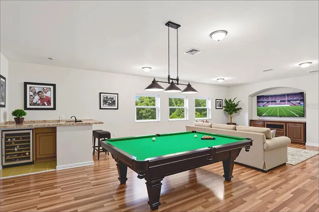 a room with furniture pool table and window