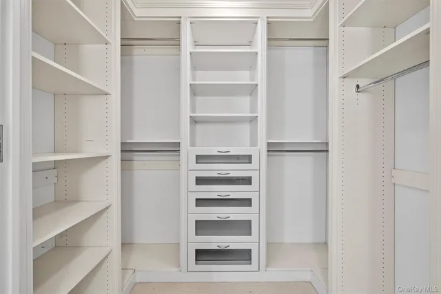a view of walk in closet with empty racks