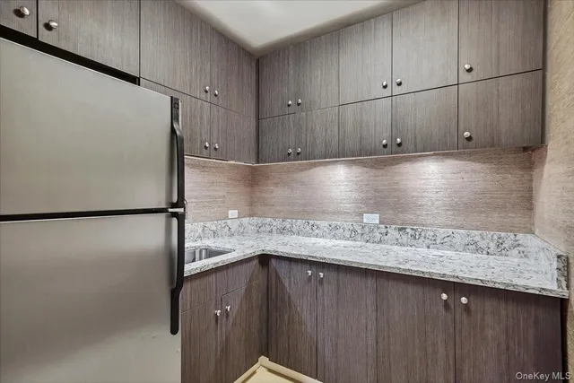 a kitchen with granite countertop a refrigerator and a sink