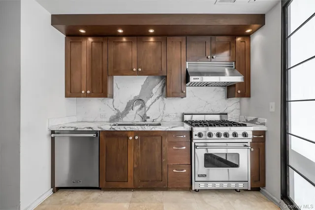 a kitchen with granite countertop stainless steel appliances and wooden cabinets