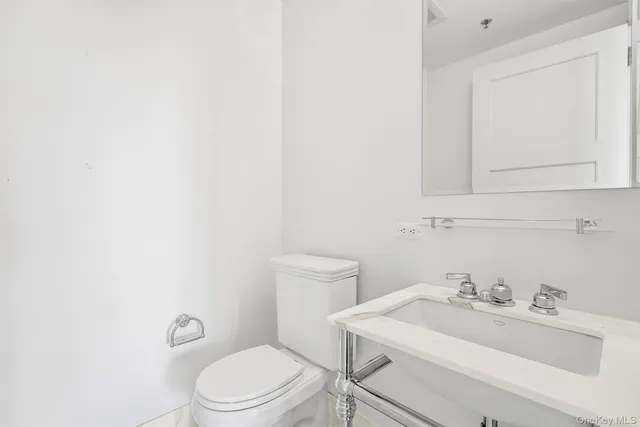 a bathroom with a sink a toilet and mirror
