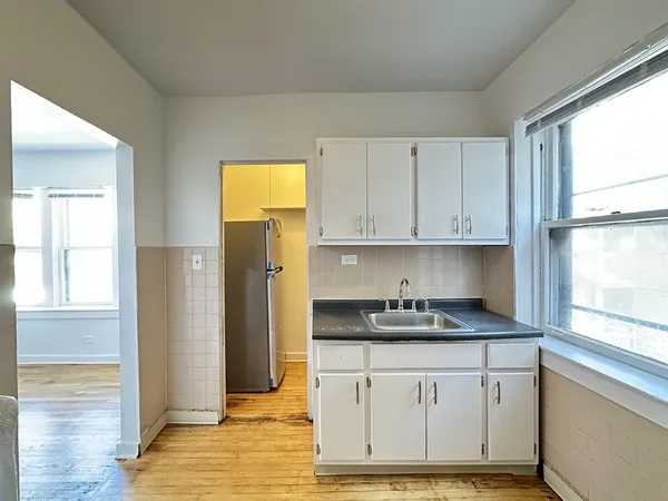 a kitchen with stainless steel appliances granite countertop white cabinets and window