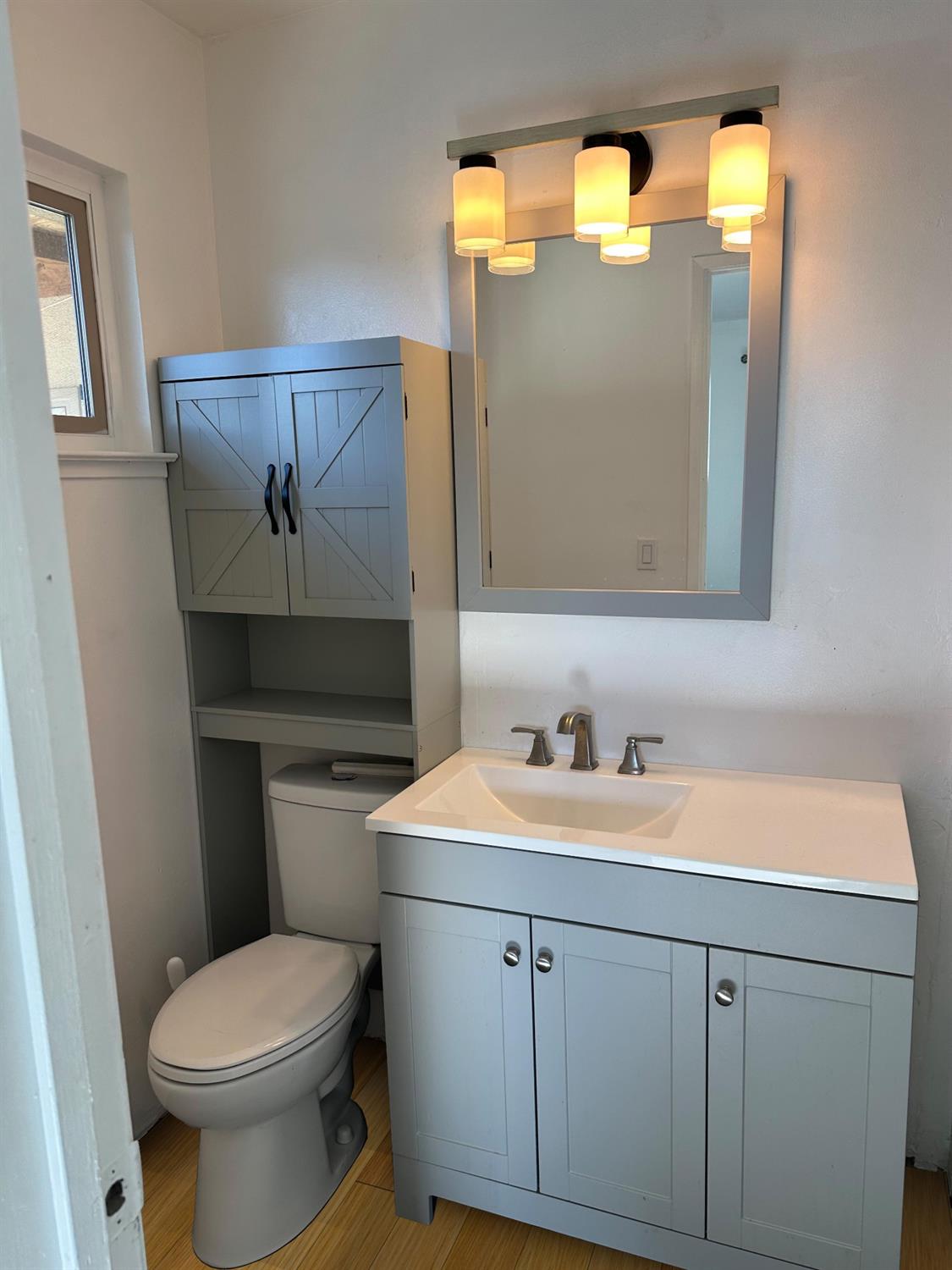 1319 Adler Drive Clovis, CA 93612 - Photo 7 of 20 a bathroom with a toilet sink and mirror