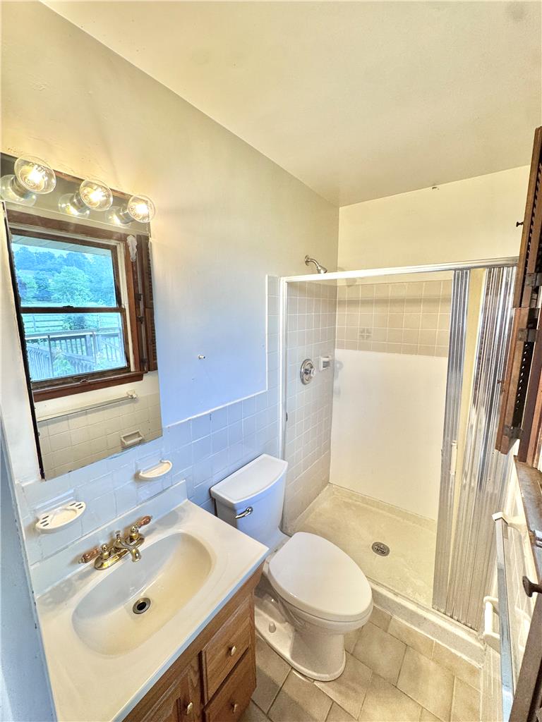 8325 Schantz Road Breinigsville, PA 18031 - Photo 16 of 21 A compact bathroom offers essential functionality with a vanity, toilet, and walk-in shower.