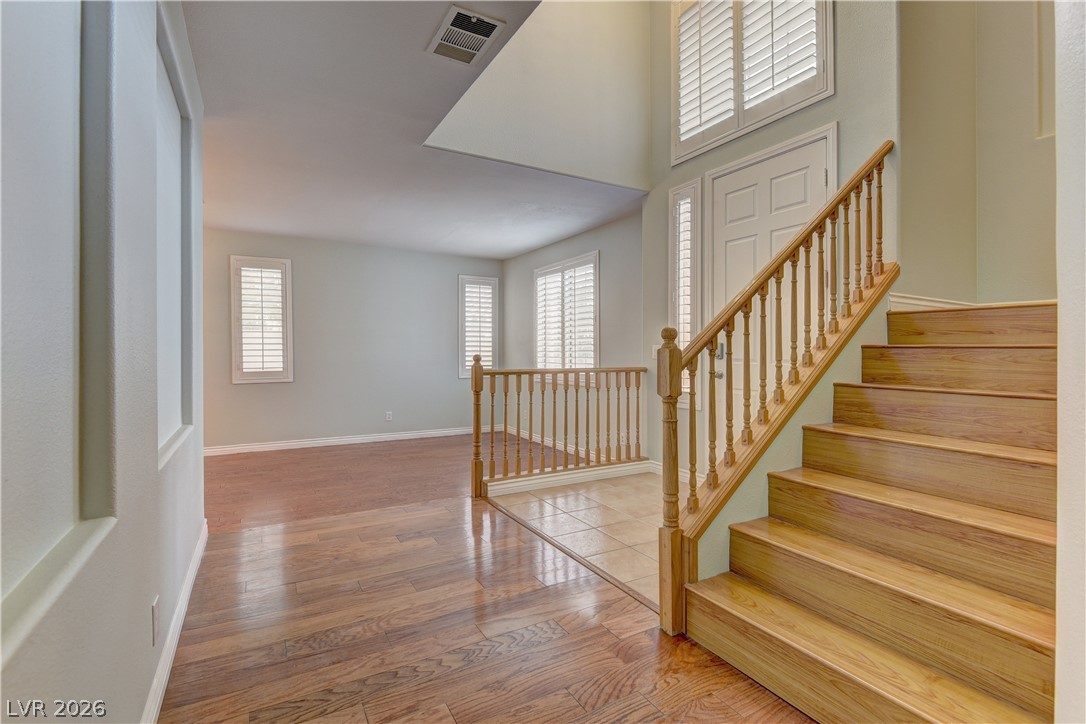 1813 Snow Spring Lane Las Vegas, NV 89134 - Photo 5 of 37 A graceful staircase with warm wood finishes welcomes you into this luminous entryway.