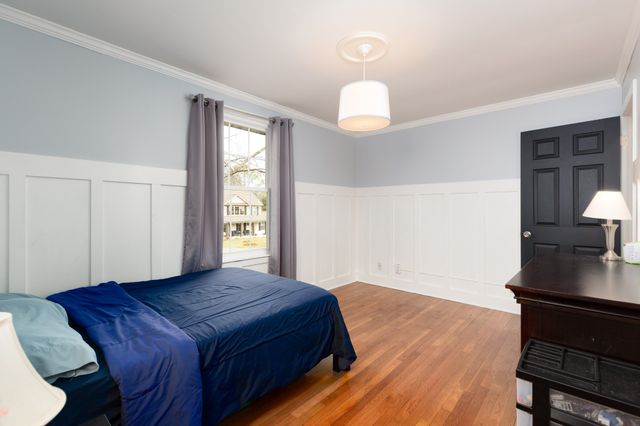 a spacious bedroom with a bed and a potted plant next to a window